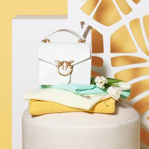 Biała torebka Pinko 1080 zł, turkusowy top Guess 289 zł, jasno-żółty sweterek Betty Barclay 549 zł, żółty sweter Weekend by Max Mara 739 zł, naszyjnik Swarovski 429 zł, kolczyki Swarovski 249 zł